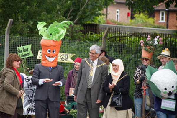 A man with a carrot head meets the Mayor and Mayoress of Ealing
