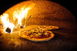Traditional Neopolitan Pizza cooking in wood burning oven from Santa Maria