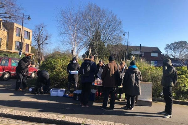 Soup kitchen volunteers handing out food in Ealing